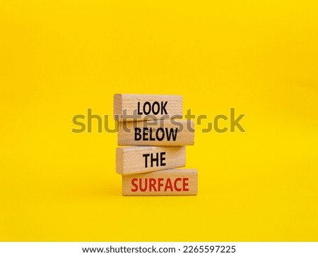 Look below the surface symbol. Concept word Look below the surface on wooden blocks. Beautiful yellow background. Business and Look below the surface concept. Copy space