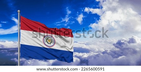 Paraguay national flag cloth fabric waving on beautiful blue sky.