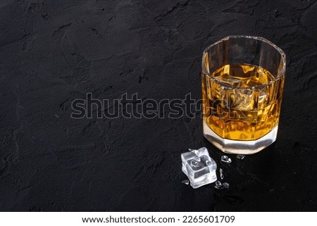 Glass of golden whiskey with ice. Strong alcoholic drink background. Royalty-Free Stock Photo #2265601709