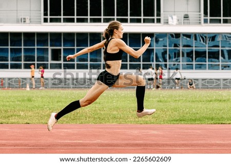 young female athlete triple jump on track stadium Royalty-Free Stock Photo #2265602609
