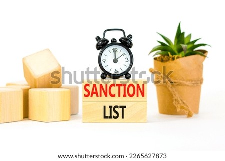 Sanction list symbol. Wooden blocks with concept words Sanction list on beautiful white background. Black alarm clock. Business political sanction list concept. Copy space.