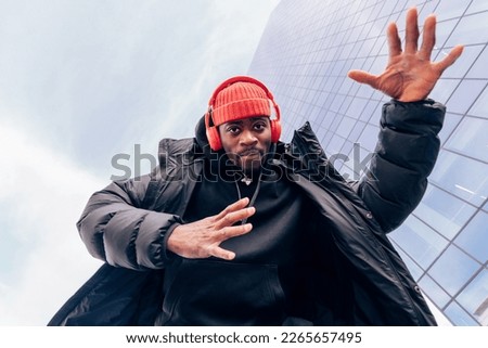 Upbeat Vibes - Low-Angle Street Fashion Portrait of a Super Cool African American Man Dancing to Hip-Hop Beats Groove Royalty-Free Stock Photo #2265657495