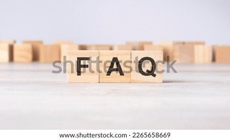 FAQ - acronym concept written on wooden cubes or blocks on a light grey background