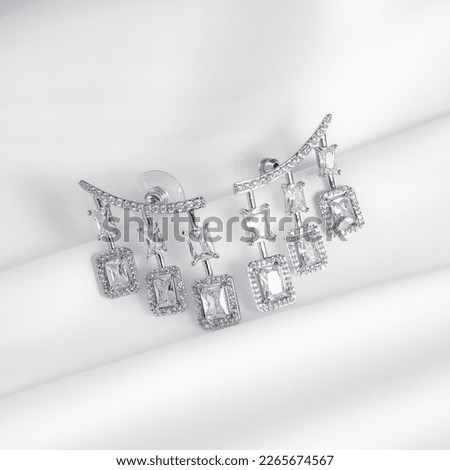 2 silver earrings with diamonds
