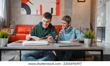 One student teenage caucasian man study learn with help of his tutor professor or mother senior woman at home having private lesson to prepare for exam education concept real people copy space Royalty-Free Stock Photo #2265696497