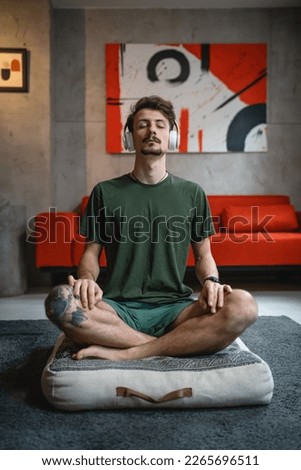 one man adult caucasian male on the floor use headphones for online guided meditation practicing mindfulness yoga with eyes closed at home real people self care manifestation concept copy space Royalty-Free Stock Photo #2265696511