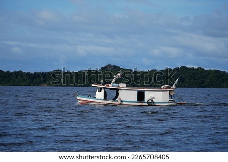 Typical Amazon boat on the Rio Negro in front of the Anavilhanas archipelago. Near Novo Airao, Amazonas state, Brazil.                         Royalty-Free Stock Photo #2265708405
