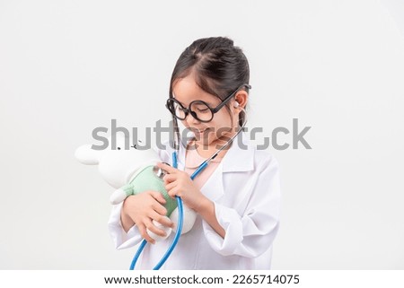 Asia little girl playing doctor and little rabbit doll isolated on white