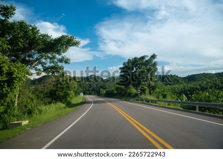 Highway in the Colombian countryside with a no overtaking traffic sign on the road.