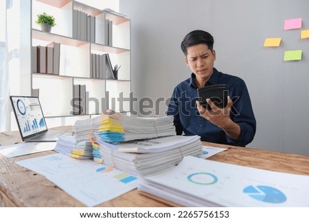 Hand of stress young asian businessman,male is pressing a calculator to calculate tax income and expenses, bills, credit card for payment or payday at home, office.Financial, finance concept Royalty-Free Stock Photo #2265756153