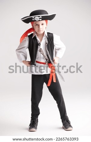 A full-length shot of a cute little boy wearing a costume of a pirate. Party with costumes for kids. White studio background.