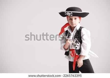 A shot of a cute little boy wearing a costume of a pirate. Party with costumes for kids. White studio background with copy space.