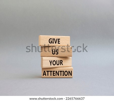 Attention symbol. Concept word Give us your attention on wooden blocks. Beautiful grey background. Business and Give us your attention concept. Copy space