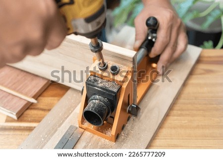 Carpenter use drill bit Pocket hole joinery, or pocket screw joinery, involves drilling a hole at an angle ,make strong joints on wooden plate. D.I.Y and woodworking concept.selective focus. Royalty-Free Stock Photo #2265777209