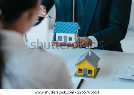 Choose a model home, realtor suggestion a new house model assisting client to sign contract agreement with insurance to happy living building, concerning mortgage loan offer