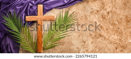 Lent season, Holy week and Good friday concept. Palm leave and cross on stone background Royalty-Free Stock Photo #2265794121