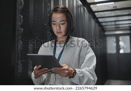 Tablet, server room and security with a programmer asian woman at work on a computer mainframe. Software, database and information technology with a female coder working alone on a cyber network Royalty-Free Stock Photo #2265794629