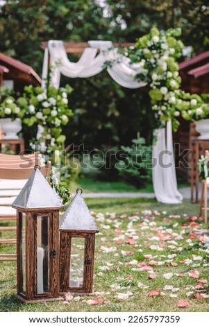 Open air wedding ceremony with wedding arch decorated with flowers and white fabric. High quality photo