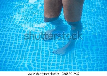 Closeup shot of woman legs in the pool, shallow water pool Royalty-Free Stock Photo #2265801939