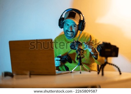 content creator recording vlog using digital video camera saying thank you for watching his show in home studio Royalty-Free Stock Photo #2265809587