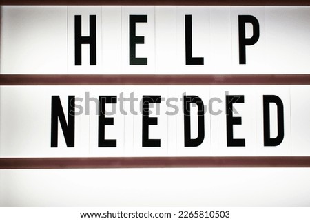 The words "Help Needed" on a light-up sign board