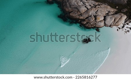 Aerial view, blue shallow water in south-west Australia. Beach in Bremer Bay. Rocks and water. Little foamy waves. Transparent water. Drone picture.