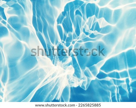 Closeup​ blur​ abstract​ of​ surface​ blue​ water. Abstract​ of​ surface​ blue​ water​ reflected​ with​ sunlight​ for​ background.Top​ view​ of blue​ water.​ Water​ splashed​ use​ for​ graphic​ design