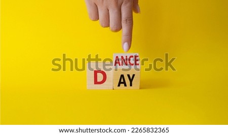 International Dance Day symbol. Businessman hand points at turned wooden cubes with words Dance day. Beautiful yellow background. International Dance Day concept. Copy space.