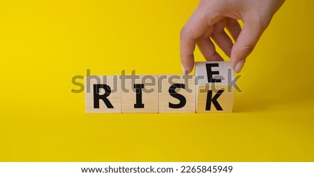 Rise vs Risk symbol. Hand turns cubes and changes the word Risk to Rise. Beautiful yellow background. Businessman hand. Business and Rise vs Risk concept. Copy space