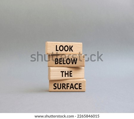 Look below the surface symbol. Concept word Look below the surface on wooden blocks. Beautiful grey background. Business and Look below the surface concept. Copy space