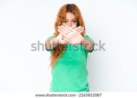 Young caucasian woman isolated on white background making stop gesture with her hand to stop an act