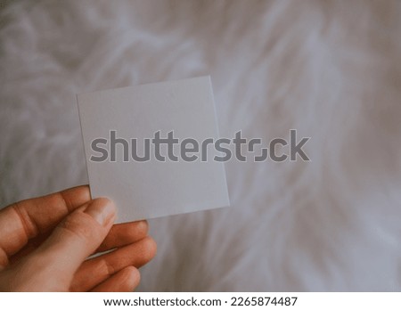 Close up picture of Hand holding a blank white card on white background. woman keeping blank business card on white isolated studio background, copy space, cutout. 