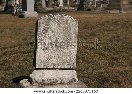 Worn and weathered, simple and plain, natural stone tombstone with a blank epitaph and room for text. Royalty-Free Stock Photo #2265875169