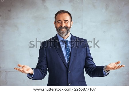 Portrait of mature businessman at modern office. Happy satisfied mature businessman looking at camera isolated on gray background. Satisfied proud man feeling confident in a modern office.