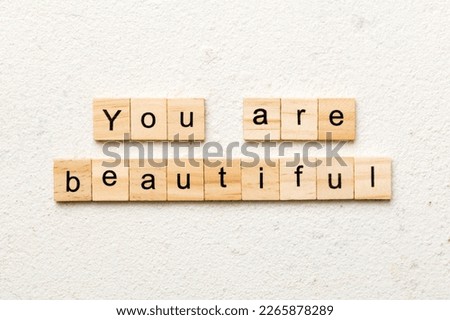 You are beautiful word written on wood block. You are beautiful text on cement table for your desing, Top view concept.