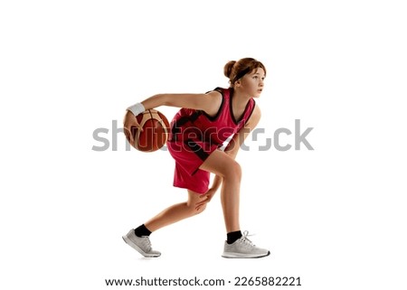 Concentration. Teen girl, basketball player in motion with ball, dribbling isolated over white studio background. Concept of sportive lifestyle, active hobby, health, endurance, competition