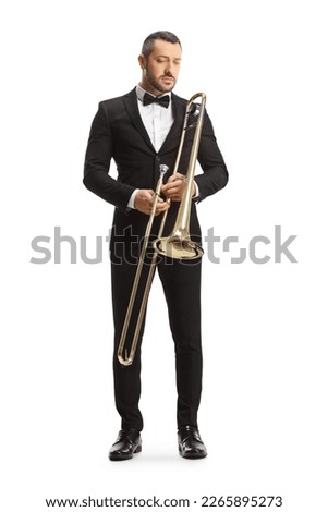 Full length portrait of a male musician holding a trombone and looking down isolated on white background Royalty-Free Stock Photo #2265895273