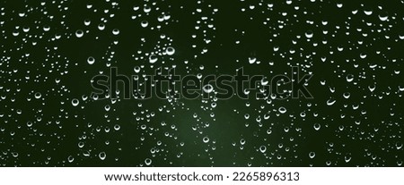 Atmospheric minimal monochrome backdrop with rain droplets on glass. Wet window with rainy drops and dirt spots closeup. Blurry minimalist background of dirty window glass with raindrops close up.