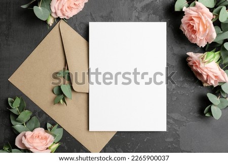 Invntation or greeting card mockup with envelope and roses flowers on dark background, blank mockup Royalty-Free Stock Photo #2265900037