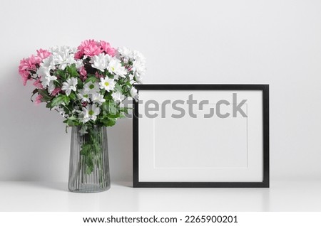 Blank landscape frame mockup with fresh flowers bouquet in white room interior, blank mockup with copy space