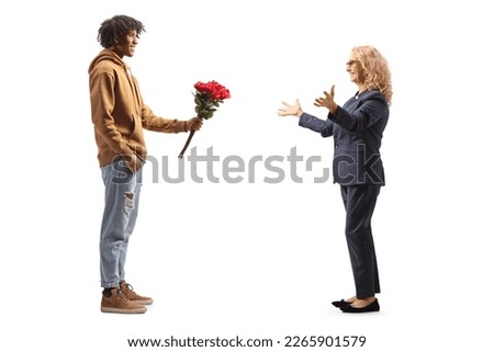 Young african american man giving red roses to a surprised mature woman isolated on white background
