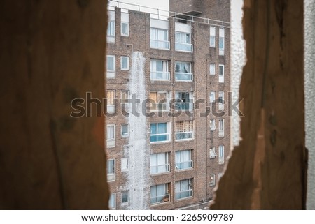 An old council block seen through a broken window in Grahame Park housing estate in London Royalty-Free Stock Photo #2265909789