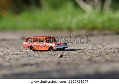 a toy car, orange in color with a fire motif


