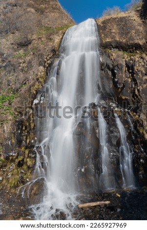 Spring waterfall flowing down a cliff

