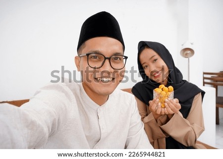 Photo of asian couple moslem  selfie use cellphone cameras during Eid Mubarak 