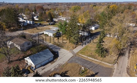 Trailer park with new development prefabricated houses at a low-income housing neighborhood in Rochester, Upstate New York, USA. Aerial view prefabricated modular home and colorful fall foliage