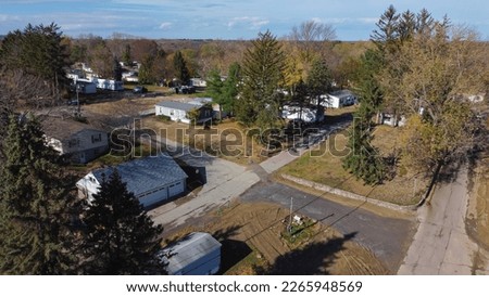 Trailer park with new development prefabricated houses at a low-income housing neighborhood in Rochester, Upstate New York, USA. Aerial view prefabricated modular home and colorful fall foliage