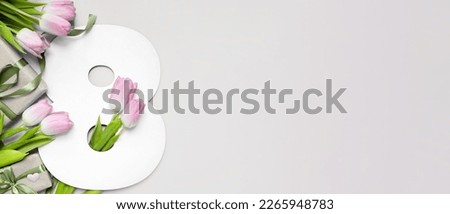festive mockup figure eight shape with pink tulips  on a grey background. copy space. top view. flat lay. concept of international women's day, march 8. banner