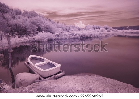 Infrared photography - a small boat docked by the pond.