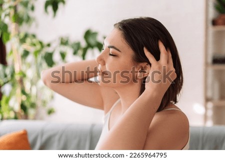 Lady enjoys giving herself a head massage. Royalty-Free Stock Photo #2265964795